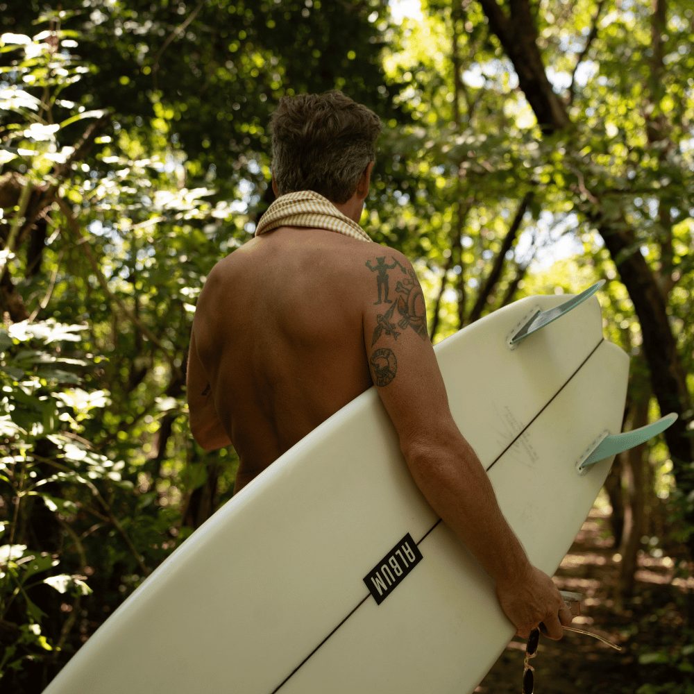 Surfer walking through the jungle in Nosara